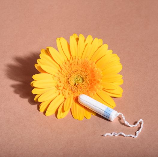 a tampon set against a yellow flower to denote that it is eco friendly