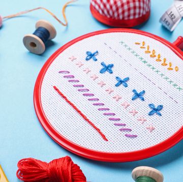 embroidery and different sewing accessories on light blue background