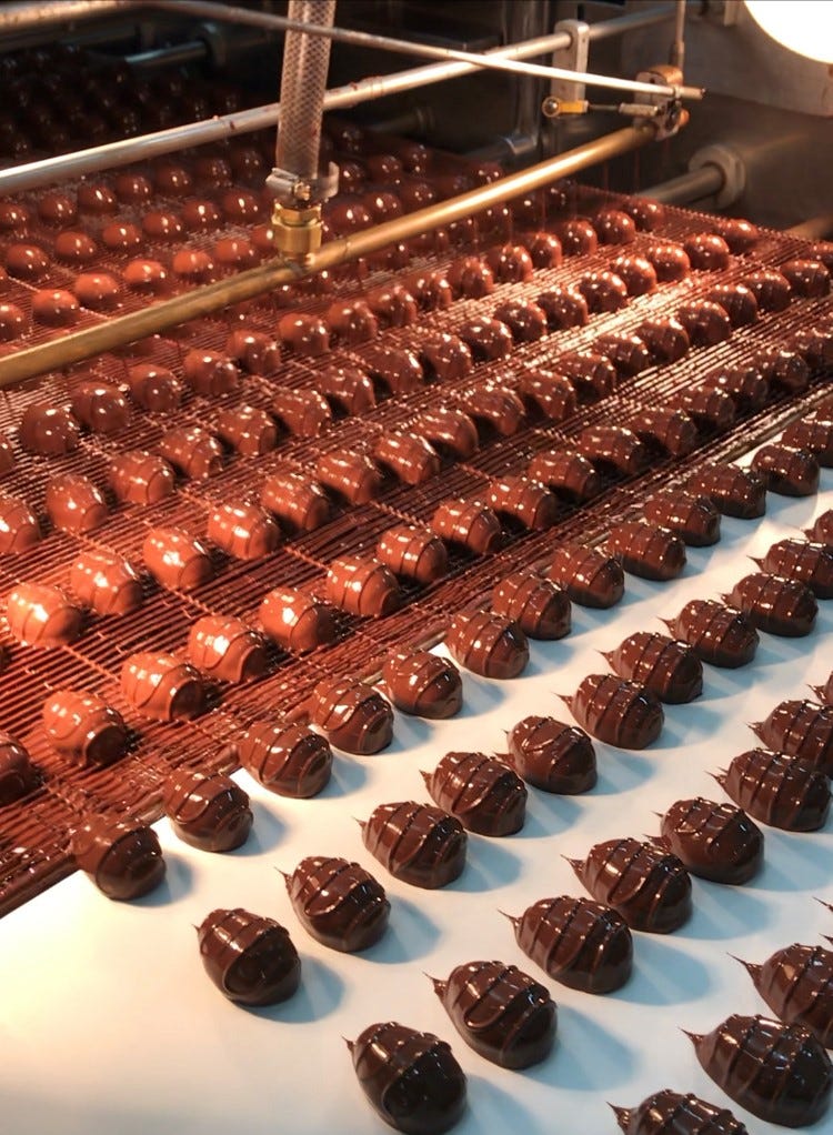 fannie may candies getting coated in chocolate as part of the fanny may factory tour, a good housekeeping pick for best factory tours