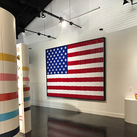 an american flag made of kazoos hangs in the kazoo factory, a good housekeeping pick for best factory tours