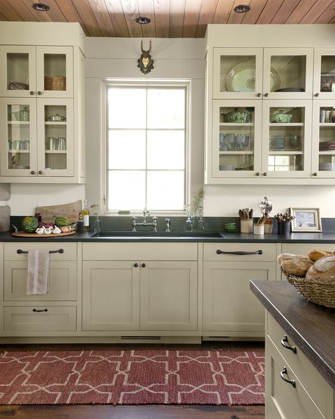 a kitchen with tan cabinets and black countertops