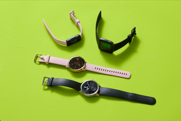 four black and pink fitness watches for women with green background