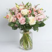 bouquet of white and pink flowers and clear vase bouquet of red, pink, white, and peach flowers in burlap sack tied with ribbon