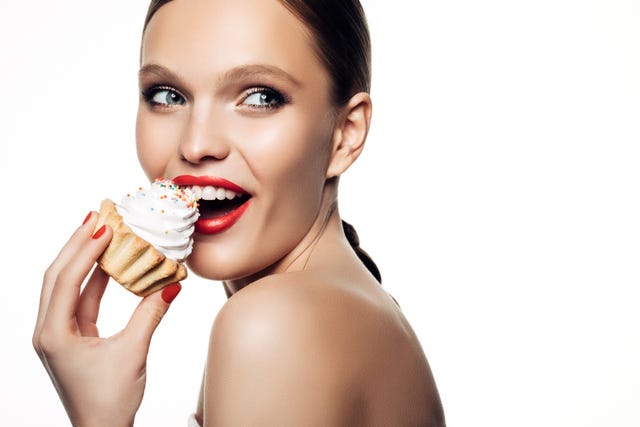laughing beautiful women hold little colorful cake