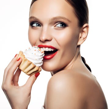 Laughing beautiful women hold little colorful cake laughing beautiful women hold little colorful cake