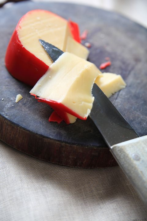 high angle view of dutch edam cheese and knife of cutting board