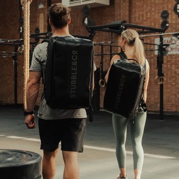 a man and woman walking wearing gym bags