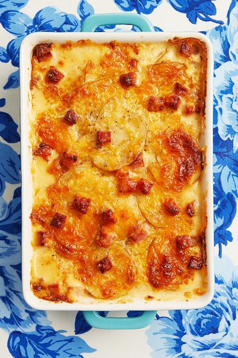 scalloped potatoes and ham in casserole on blue floral linen