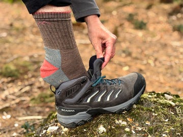 a person putting their foot into a hiking shoe