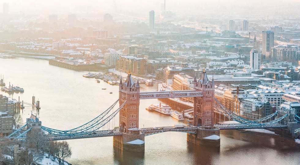 an elevated view of tower bridge and the london skyline at sunrise after snowfall