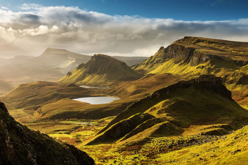 scenic view of quiraing mountains in isle of skye, scottish highlands, united kingdom sunrise time with colourful an rayini clouds in background