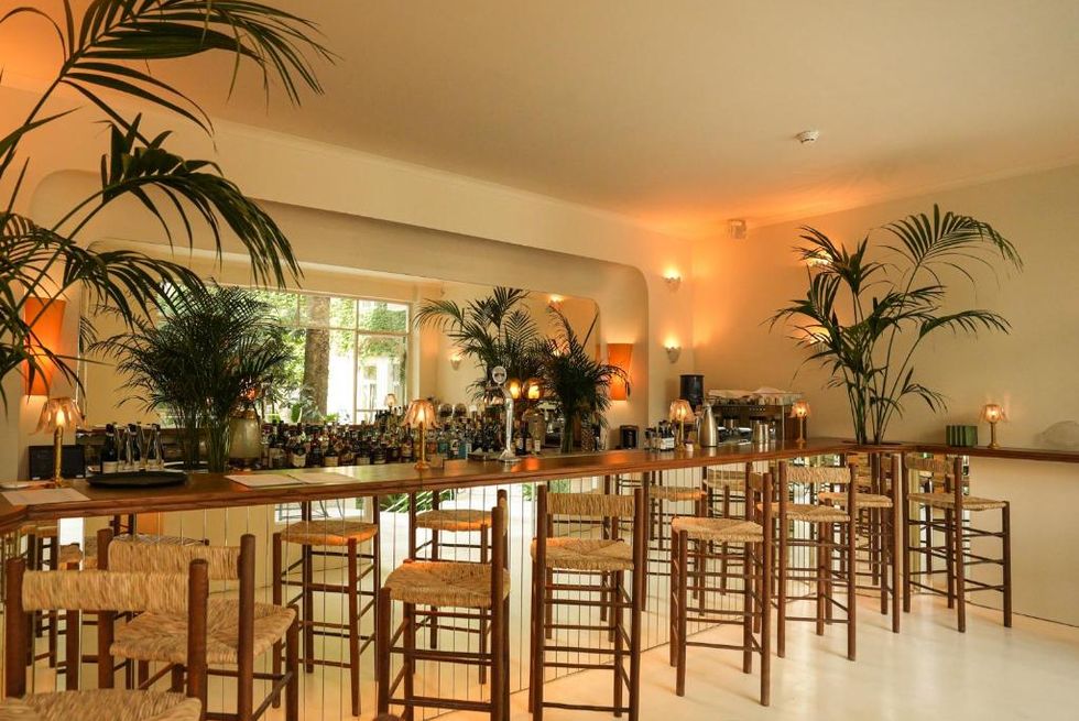 a large dining room with a bar and chairs