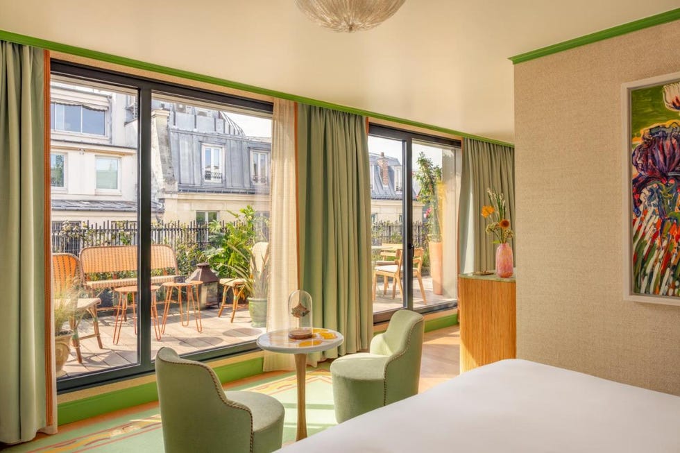 a room with a bed and chairs