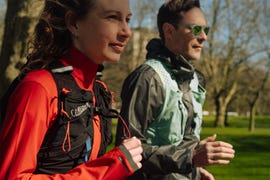 two people running side by side wearing hydration vests
