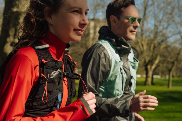two people running side by side wearing hydration vests