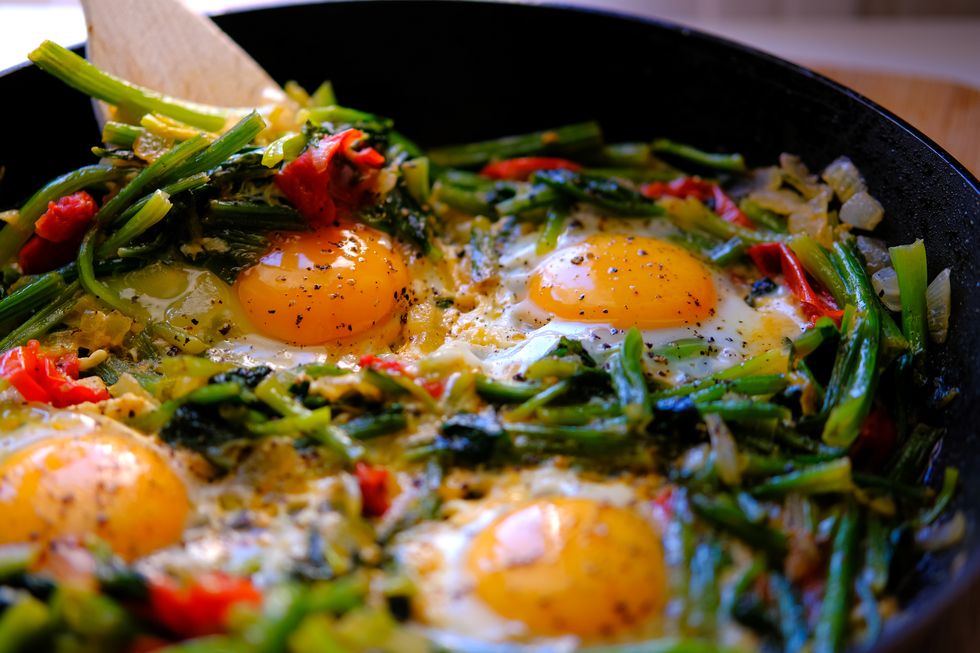 soft poached sunny side up eggs with spinach in a frying pan healthy trendy breakfast low fat brunch