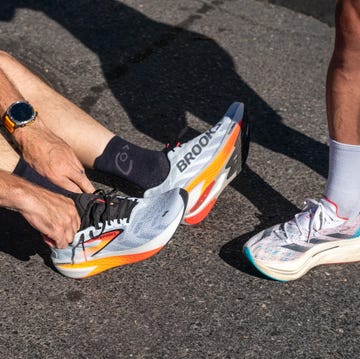 a person lacing up running shoes on a street