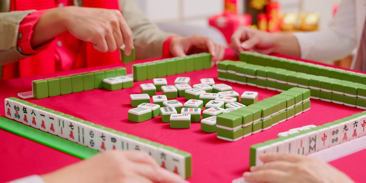 chinese new year concept close up of asian family hands play mahjong at home