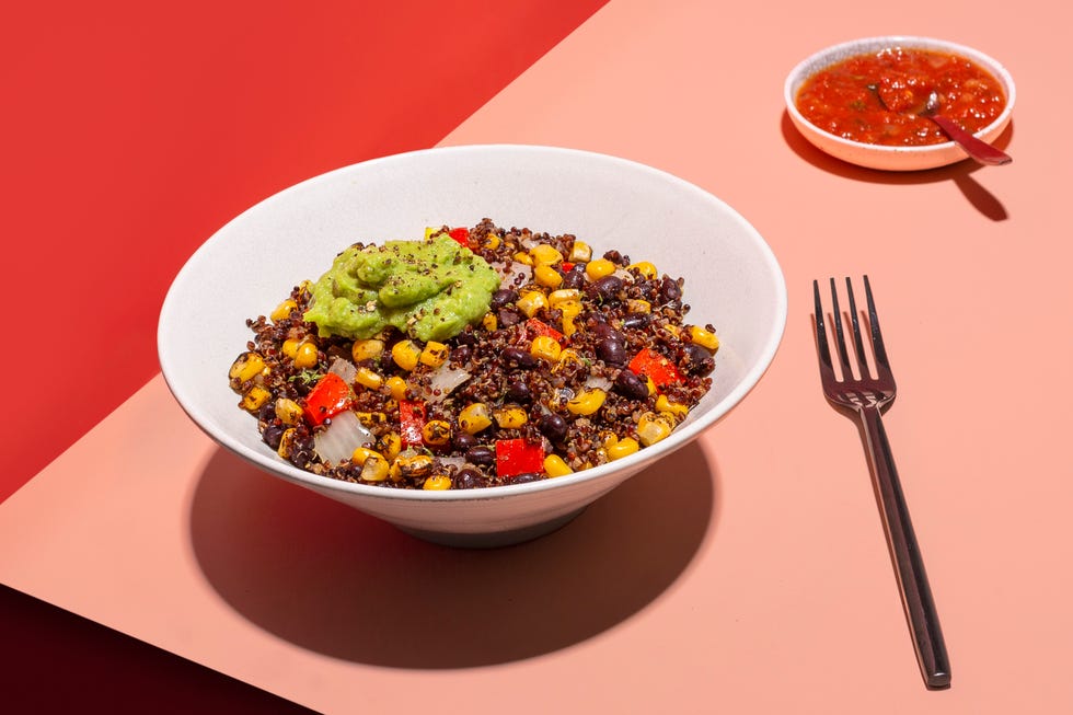 a grain bowl with guacamole on a red and pink background from sunbasket, a good housekeeping pick for best healthy meal delivery service