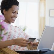 black woman shopping online with credit card
