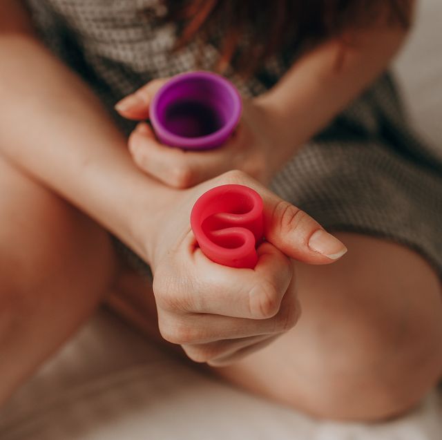 a woman folds a menstrual cup in her hands