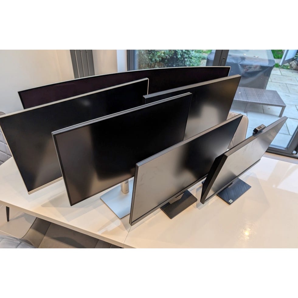 multiple computer monitors for testing arranged on a table