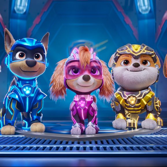 the mighty pups stand proud in a line while wearing glowing suits in a scene from paw partrol the mighty movie, a good housekeeping pick for best kids movies 2023