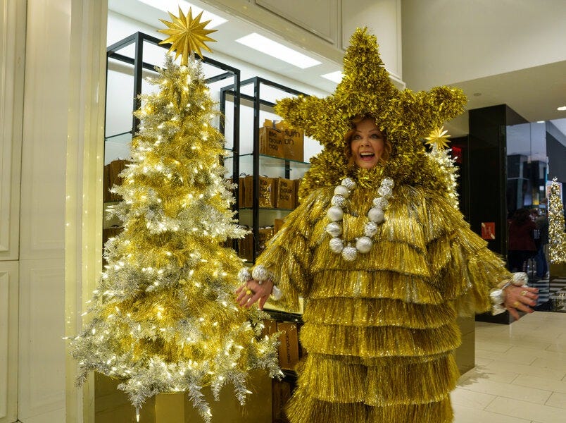 a genie played by melissa mccarthy wears a christmas tree outfit in a scene from genie