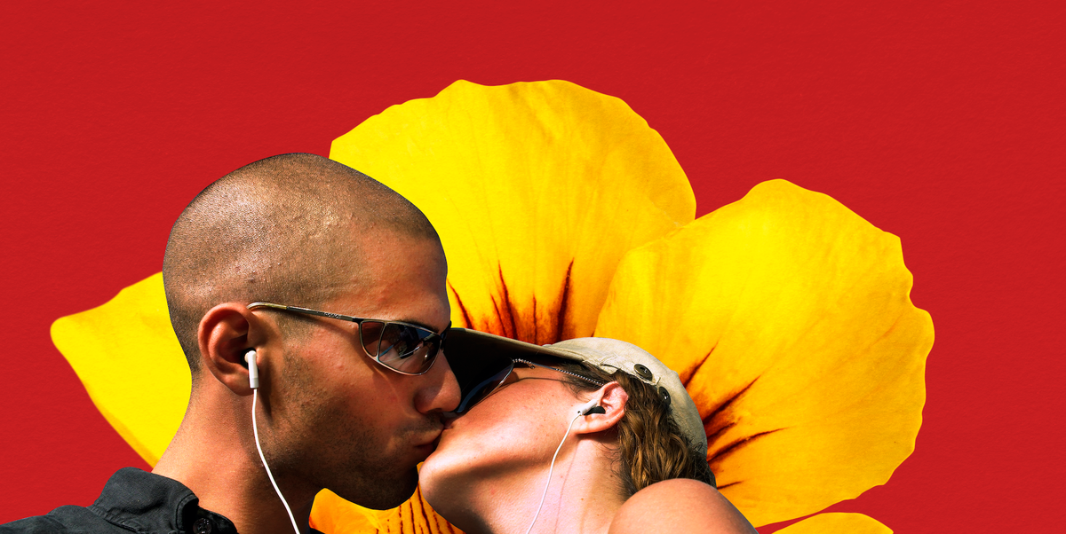two people kissing in front of a yellow flower both wearing headphones