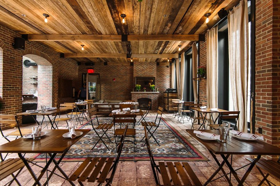 brick and wood interior of restaurant with tables and chairs