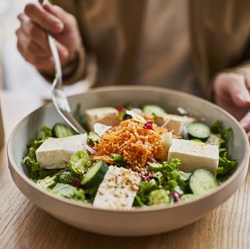 woman eats from bowl of tofu in cafe