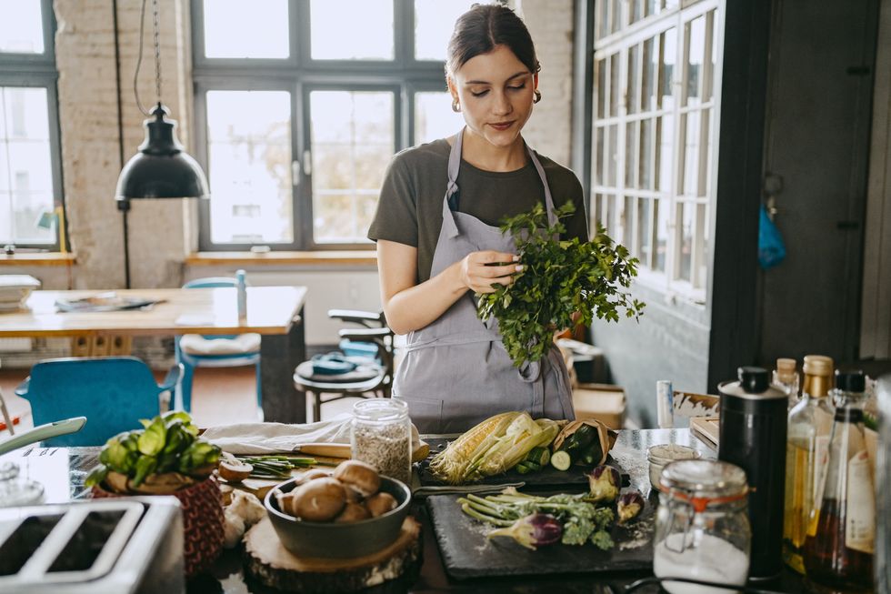 woman prepares vegetables in kitchen