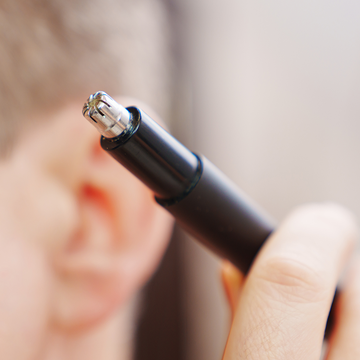 a person holding a nose hair trimmer