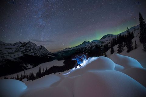 Boven het Peyto Lake in het Canadese Banff National Park ploegt een snowboarder zich door de verse sneeuw