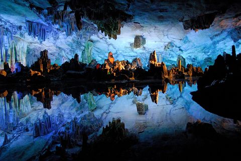 Het spiegelgladde water in de Rietfluitgrot in Guilin China weerkaatst spookachtige rotsformaties