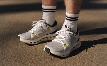 close up of a pair of grey and white on running shoes, white ankle socks with a black rim