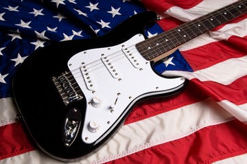 black and white guitar resting on american flag