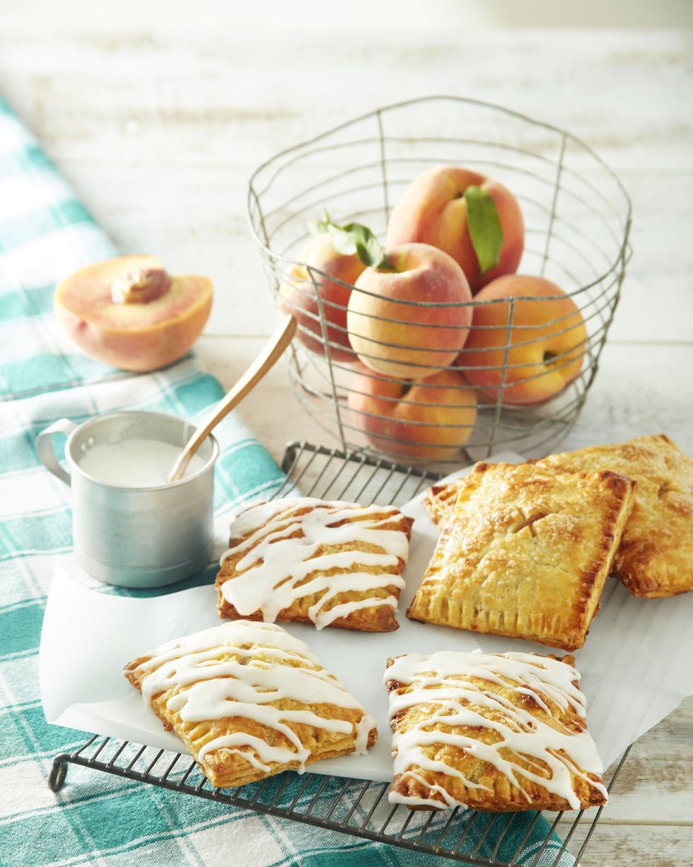 spiced peach hand pies drizzled with glaze and arranged on a wire rack