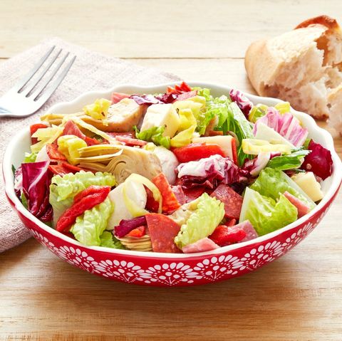 antipasti chopped salad in red bowl with crusty bread in back