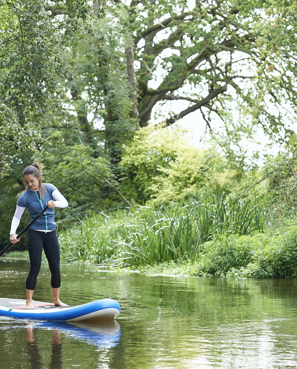 paddleboarding on the river wensum, in the wensum valley, norfolk uk