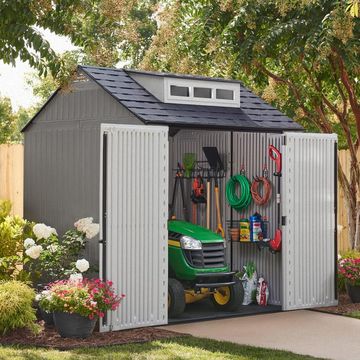plastic outdoor shed with riding mower and tools in it