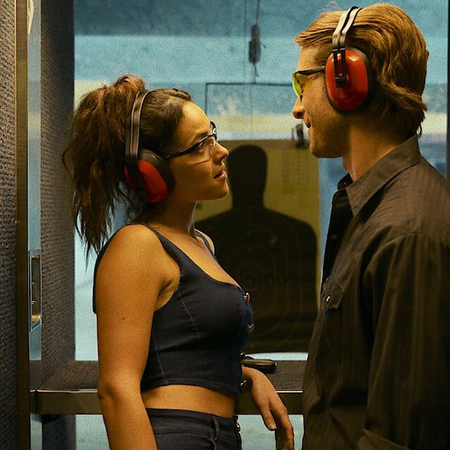 a man and woman flirt at a shooting range in a scene from hit man