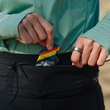 best running belt close up of a woman getting an energy gel out of a running belt