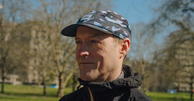 a person wearing a camouflage patterned cap in an outdoor park setting