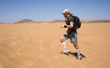 a man running through the desert wearing an array of running kit