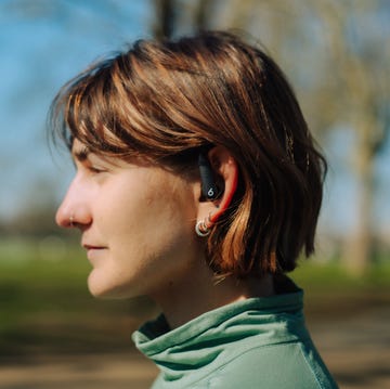 best running headphones person wearing wireless earbuds in a park