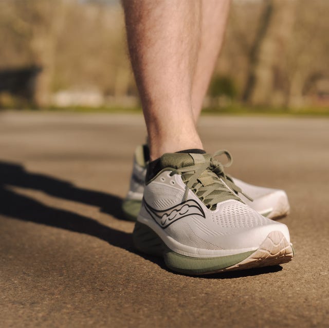 close up of a person's lower leg wearing green and grey running shoes close up of a person's lower leg wearing green and grey running shoes