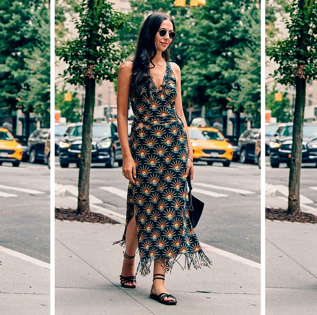 a bazaar editor wears a patterned dress and black sandals to illustrate a guide to the best sandals of 2023