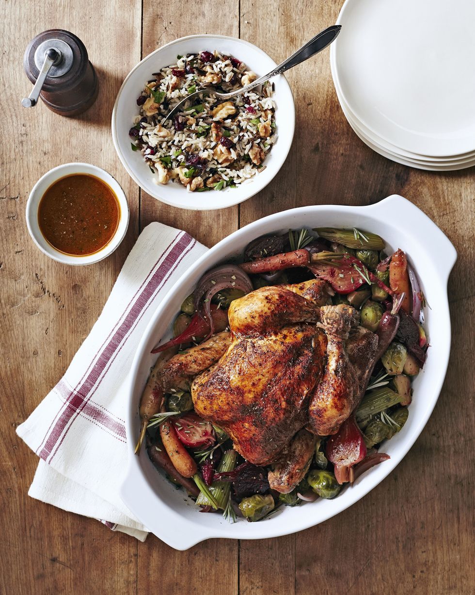 slow cooker whole herbed chicken with beets and brussels sprouts served in a white oval baking dish