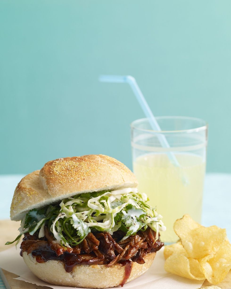 slow cooker pulled pork sandwich with kettle chips and a glass of lemonade
